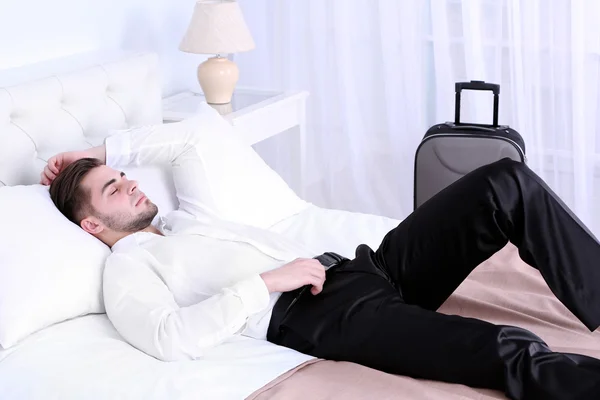 Uomo stanco che riposa sul letto in camera — Foto Stock