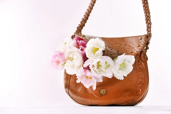 Bellissimi tulipani con borsa marrone isolata su bianco — Foto Stock