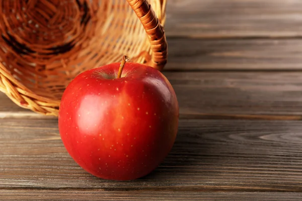 Manzana con cesta de mimbre sobre fondo de madera — Foto de Stock