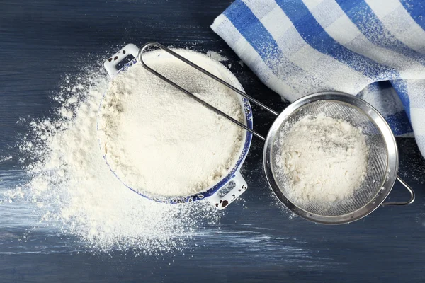 Sifting flour through sieve on wooden table, top view — Stock Photo, Image