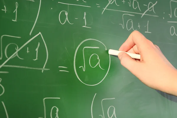 Teacher hand writing formulas on blackboard background — Stock Photo, Image