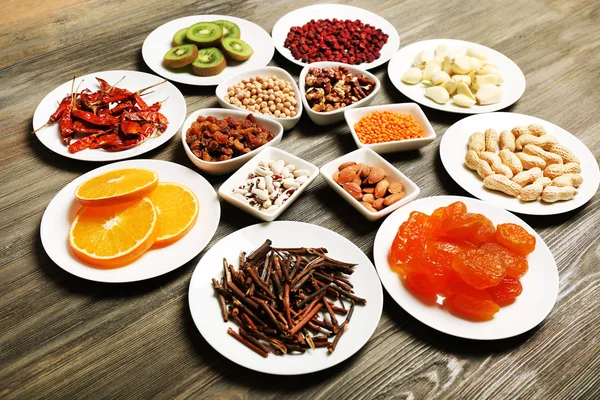 Different products on saucers on wooden table, closeup — Stock Photo, Image