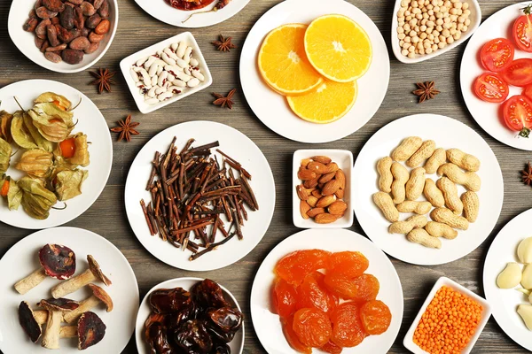 Different products on saucers on wooden table, top view — Stock Photo, Image