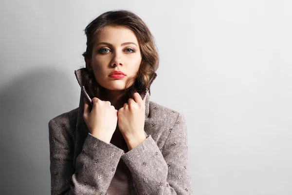 Retrato de modelo hermoso en jeans y chaqueta sobre fondo gris — Foto de Stock