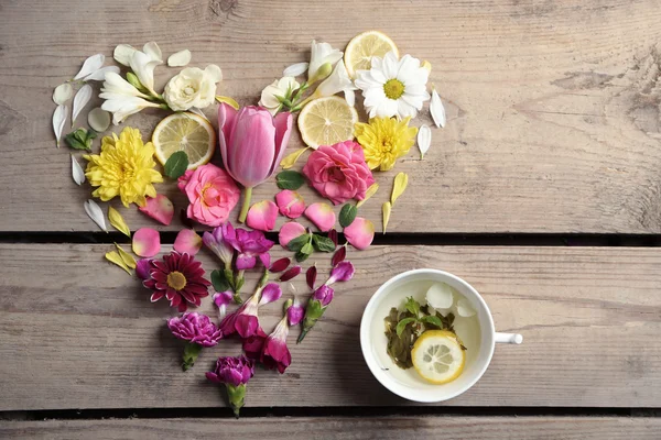 Cup of herbal tea with beautiful flowers, on wooden background — Stock Photo, Image