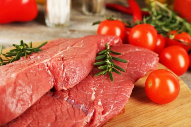 Kesme tahtası sebze ve baharat ahşap arka plan üzerinde ham sığır eti biftek