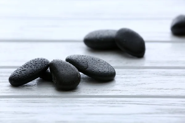 Σπα πέτρες με νερό που πέφτει σε ξύλινα φόντο — Φωτογραφία Αρχείου