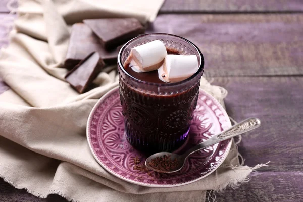 Heiße Schokolade mit Marshmallows im Glas, auf farbigem Holzgrund — Stockfoto