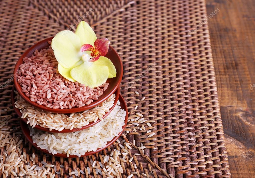 Différents types de riz dans des bols sur fond d'osier — Photo de stock ...