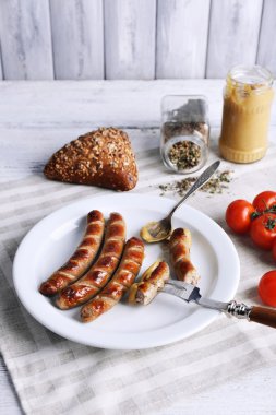 Ekmek ile plaka üzerinde ızgara sosis ve domates tablo üzerinde kapat