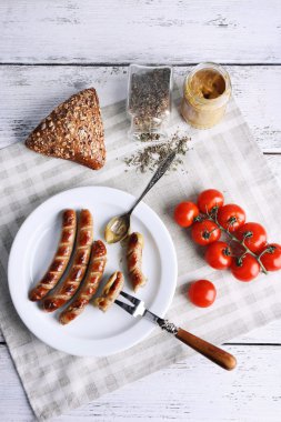 Ekmek ile plaka üzerinde ızgara sosis ve domates tablo üzerinde kapat