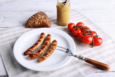 Ekmek ile plaka üzerinde ızgara sosis ve domates tablo üzerinde kapat