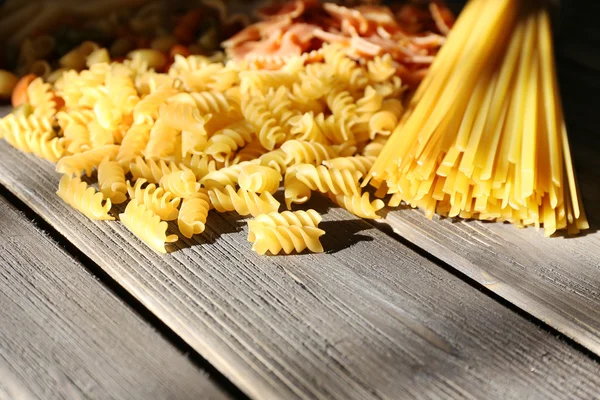 Verschiedene Arten von Pasta auf Holzplanken Hintergrund — Stockfoto