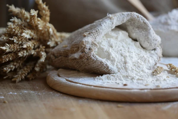 Mjöl i säckväv säck på skärbräda och träbord bakgrund — Stockfoto