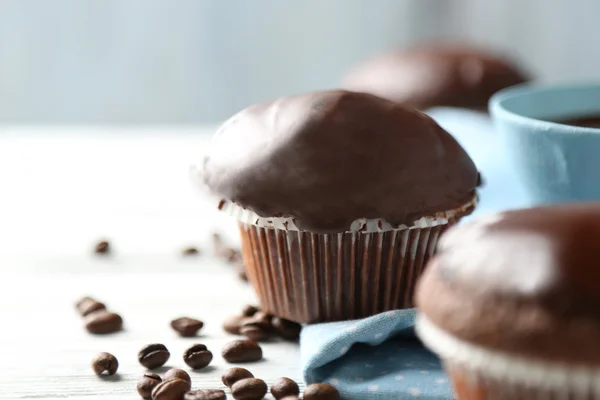 Muffins de chocolate caseiros saborosos e xícara de café na mesa de madeira — Fotografia de Stock