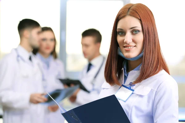 Beautiful young doctor with team in conference room — Stock Photo, Image