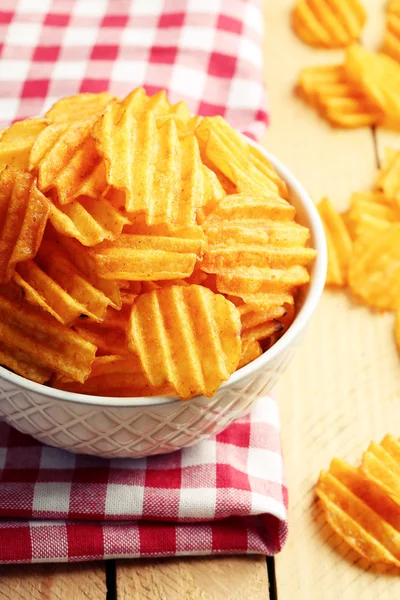 Deliciosas papas fritas en un tazón sobre una mesa de madera — Foto de Stock