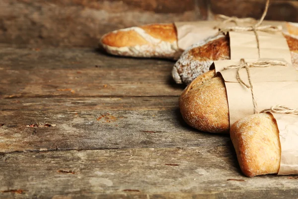 Verschillende vers brood, op oude houten tafel — Stockfoto