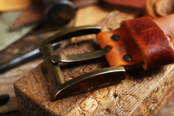 Craft tools with leather belt on table close up — Stock Photo, Image