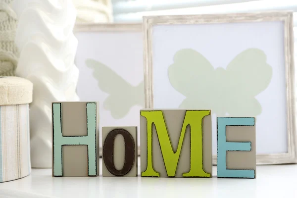 Home in colorful letters in light white interior — Stock Photo, Image