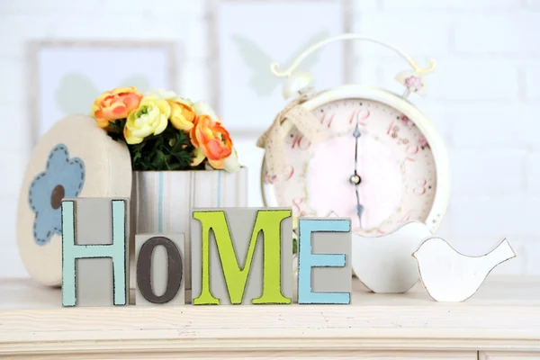 Casa en letras de colores, en el interior blanco claro, en estante de madera —  Fotos de Stock