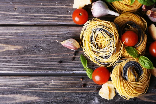 Rohe Pasta mit Käse und Gemüse auf Holzgrund — Stockfoto