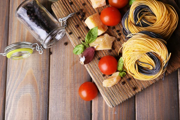 Raw pasta with cheese and vegetables on wooden background — Stock Photo, Image