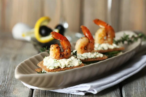 Appetizer canapé com camarão e pepino na placa na mesa de perto — Fotografia de Stock