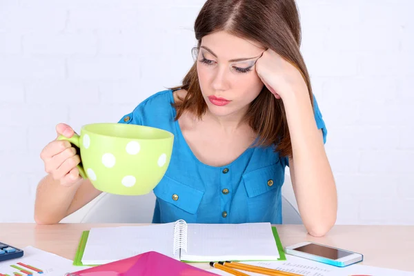 Bella ragazza seduta a tavola con grande tazza — Foto Stock