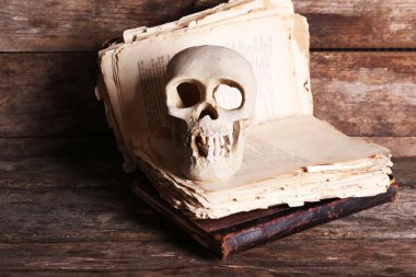 İnsan kafatası ve ahşap arka plan üzerinde retro kitap ile natürmort