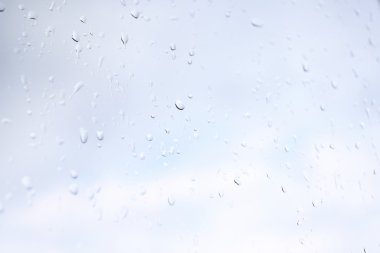 Arka sokağa bakan cam pencere üzerinde yağmur damlaları