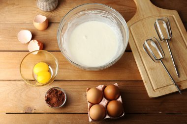 Hazırlık ahşap masa, üstten görünüm üzerinde cam kasede yumurta ile krem
