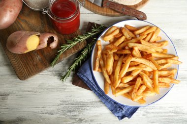 Ahşap masa arka plan üzerinde plaka üzerinde lezzetli Fransız kızartması