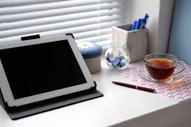 PC tablet, defter ve pencere üzerinde çay. Çalışma yeri kavramı