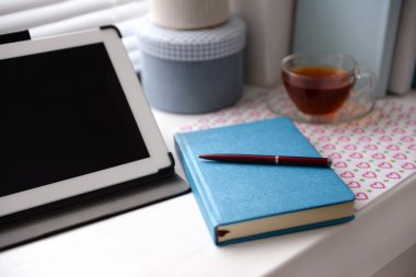 PC tablet, defter ve pencere üzerinde çay. Çalışma yeri kavramı