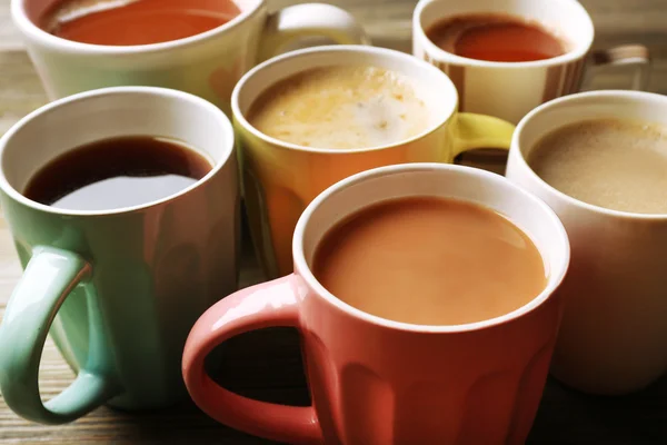 Veel kopjes koffie op houten tafel, close-up — Stockfoto