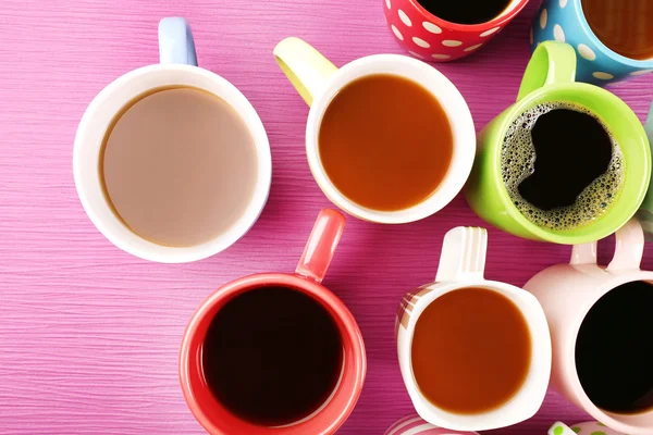 Viele Tassen Kaffee auf Farbtisch, Draufsicht — Stockfoto