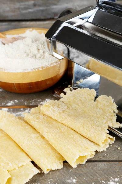 Fare vermicelli con macchina per pasta su fondo di legno — Foto Stock