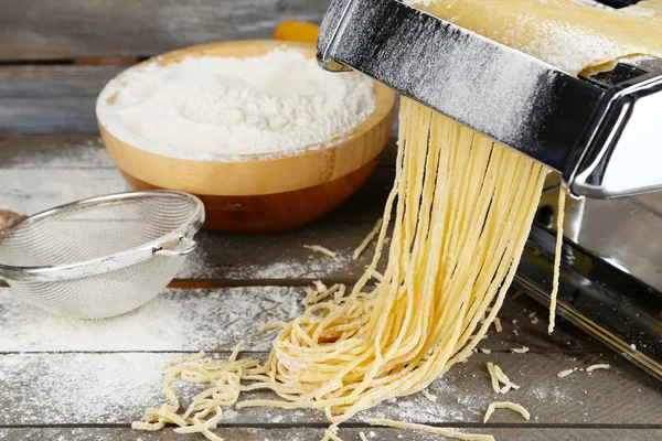 Vermicelli maken met Pastamachine op houten achtergrond — Stockfoto