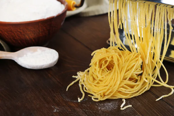 Hacer vermicelli con máquina de pasta sobre fondo de madera — Foto de Stock