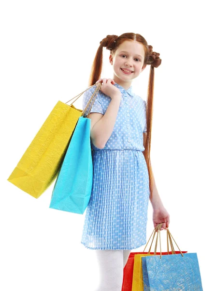 Beautiful little girl with shopping bags, isolated on white — Stock Photo, Image