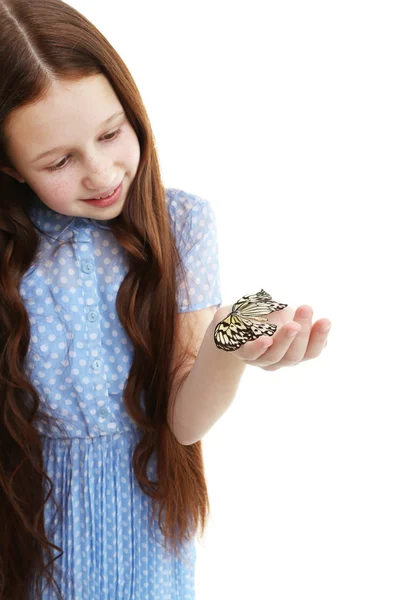 Маленька дівчинка грає з метеликом, ізольована на білому — стокове фото