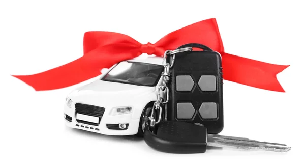 Keys with red bow near car as present isolated on white — Stock Photo, Image