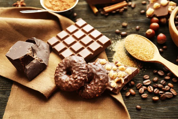 Çikolata, fındık ve ahşap masa, closeup baharat seti ile natürmort — Stok fotoğraf