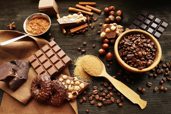 Still life with set of chocolate, nuts and spices on wooden table, closeup — Stock Photo, Image