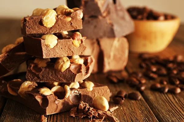 Stapel van chocolade met noten op houten tafel, close-up — Stockfoto