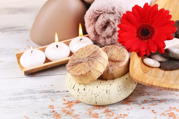 Composition of spa stones, sea salt and massage bags on wooden table, on light color background — Stock Photo, Image