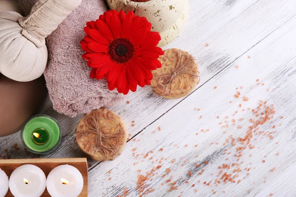 Samenstelling van spa stenen, zeezout en massage tassen op houten tafel, op lichte kleur achtergrond — Stockfoto