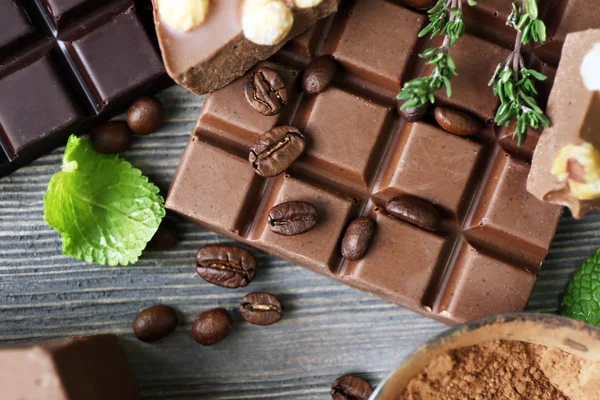 Set di cioccolato con noci, erbe e chicchi di caffè sul tavolo di legno, primo piano — Foto Stock