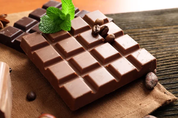 Lahodné čokolády s listy máty na stole, detail — Stock fotografie